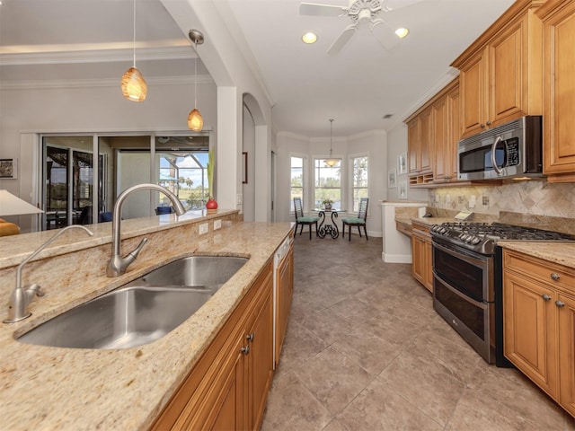 kitchen with a sink, appliances with stainless steel finishes, light stone countertops, tasteful backsplash, and crown molding