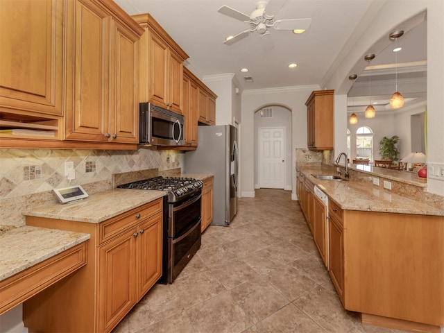 kitchen featuring appliances with stainless steel finishes, light stone counters, a sink, and ornamental molding