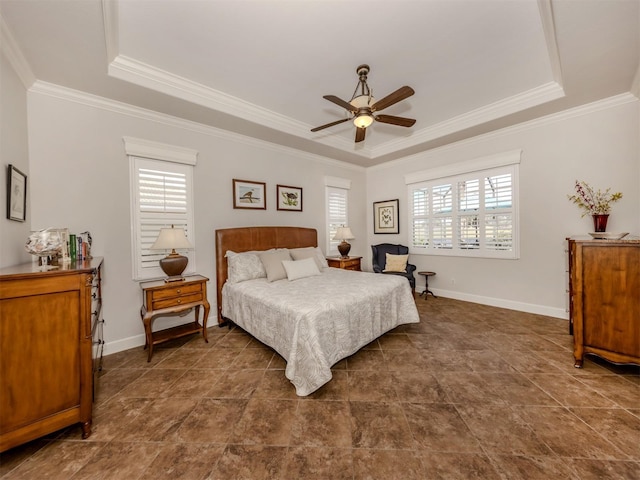 bedroom featuring baseboards, multiple windows, a tray ceiling, and crown molding