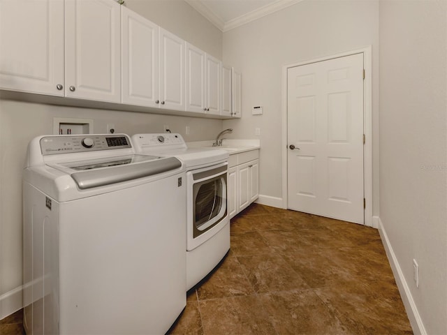 laundry room featuring a sink, baseboards, cabinet space, washer and clothes dryer, and crown molding