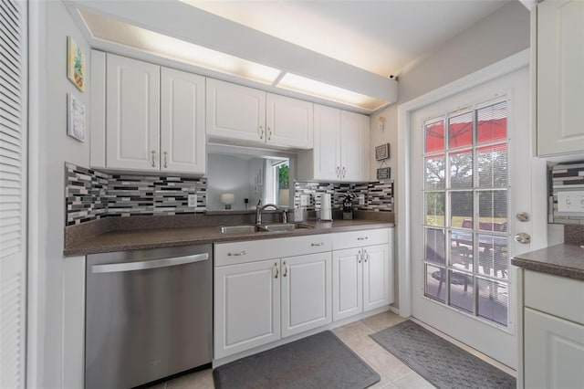 kitchen with a sink, white cabinets, backsplash, dishwasher, and dark countertops