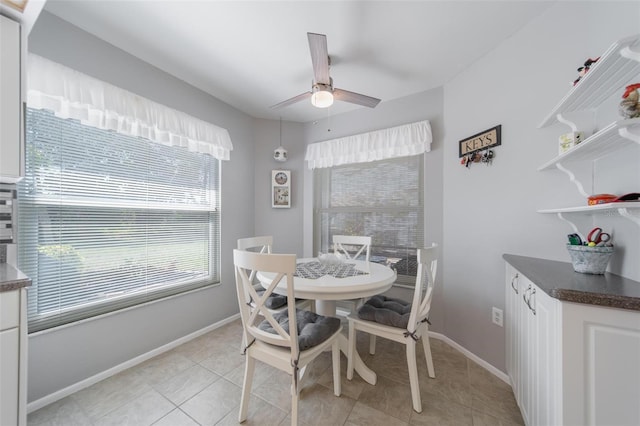 dining room with a ceiling fan, baseboards, and light tile patterned floors