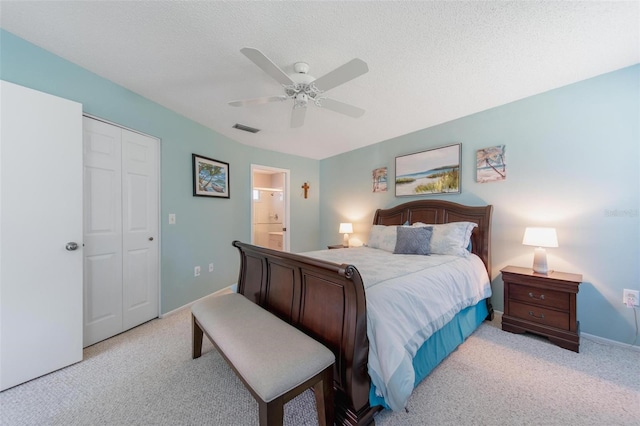 bedroom featuring light colored carpet, visible vents, ceiling fan, and a textured ceiling