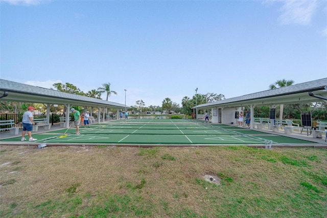 view of home's community featuring shuffleboard and a yard