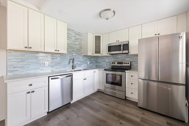 kitchen featuring light countertops, appliances with stainless steel finishes, a sink, and tasteful backsplash