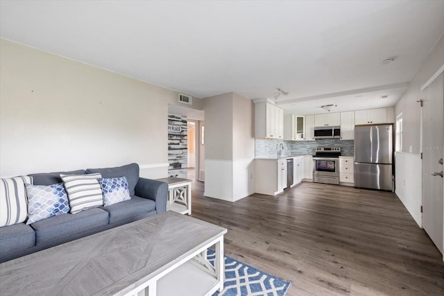 living room featuring visible vents and dark wood-type flooring