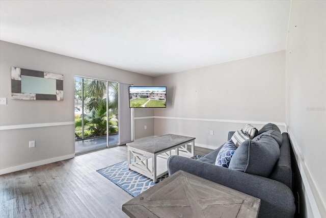 living area featuring baseboards and wood finished floors