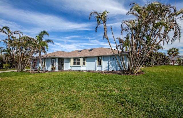 ranch-style home with a front lawn and stucco siding