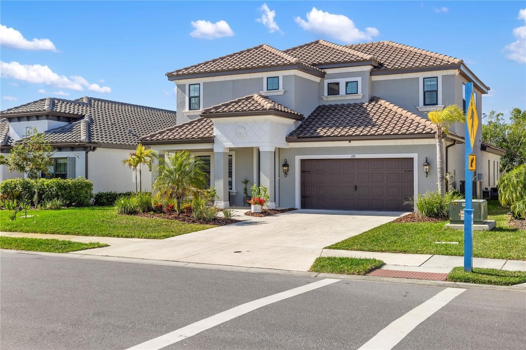 228 Caserta Ct, North Venice, FL 34275 - mediterranean / spanish-style house with concrete driveway, a tile roof, an attached garage, a front yard, and stucco siding