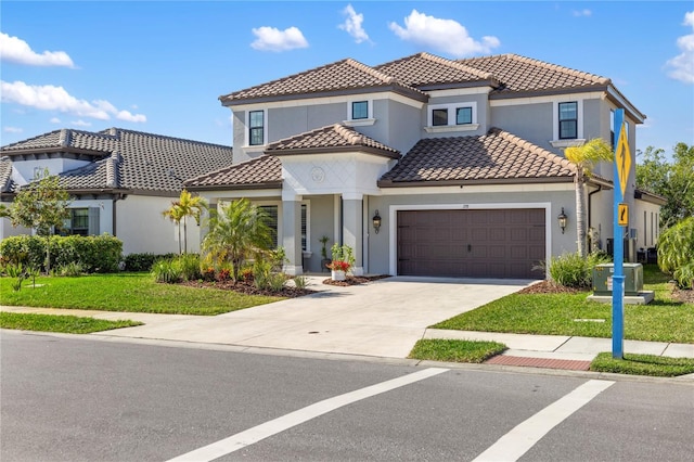 mediterranean / spanish-style house with concrete driveway, a tile roof, an attached garage, a front yard, and stucco siding