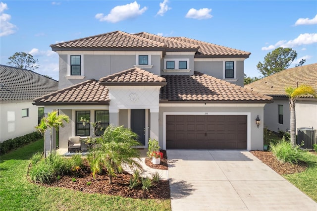 mediterranean / spanish house featuring cooling unit, a garage, driveway, a tiled roof, and stucco siding