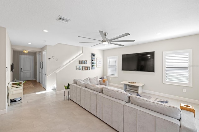 living area featuring a textured ceiling, recessed lighting, visible vents, baseboards, and a ceiling fan