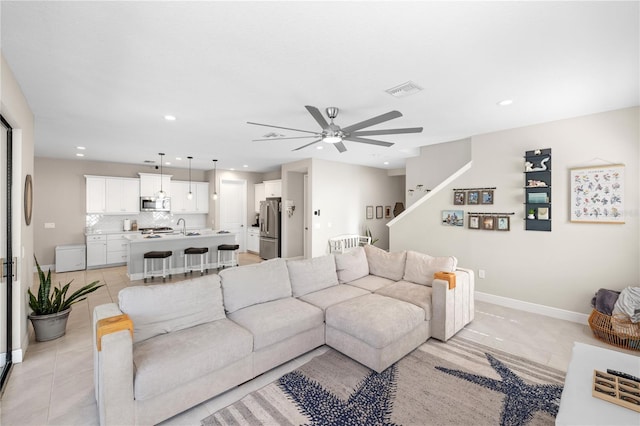 living area featuring a ceiling fan, recessed lighting, light tile patterned flooring, and baseboards