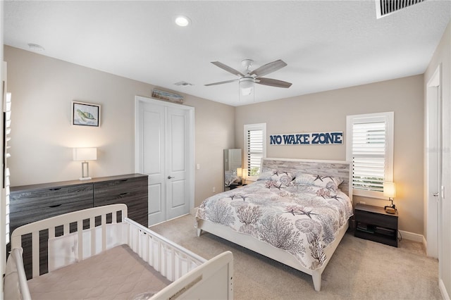 bedroom with carpet floors, ceiling fan, and visible vents