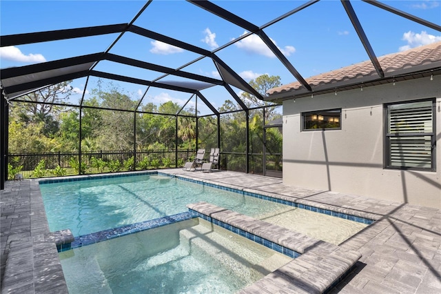 view of pool with a patio area, a pool with connected hot tub, and glass enclosure