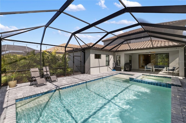 view of pool with a pool with connected hot tub, a patio area, and a lanai