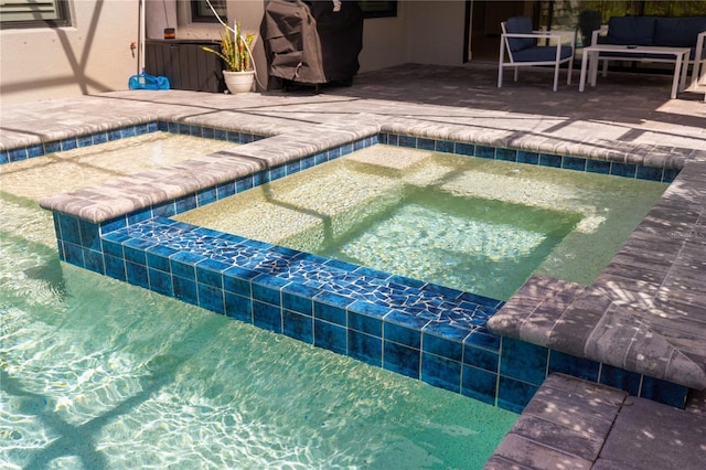 view of swimming pool featuring a patio area and an in ground hot tub