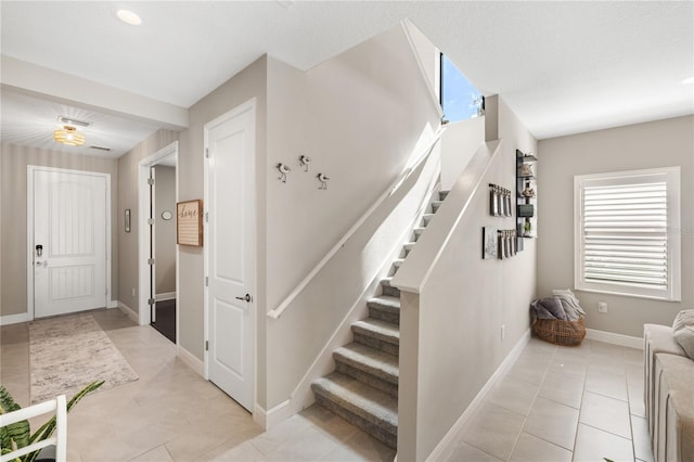 stairs featuring tile patterned flooring and baseboards