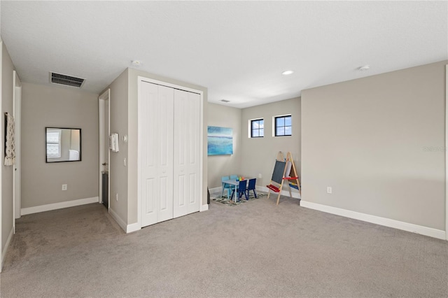 interior space with a closet, baseboards, visible vents, and carpet flooring