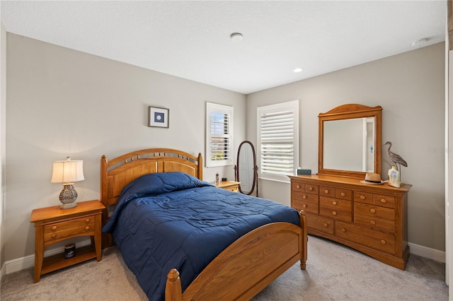 bedroom with light colored carpet and baseboards