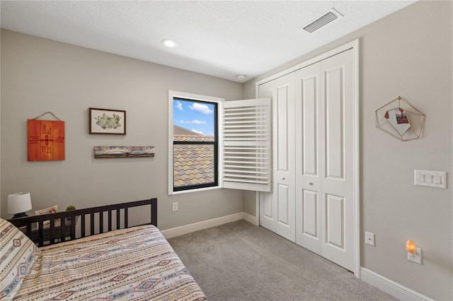 bedroom with a closet, carpet flooring, visible vents, and baseboards