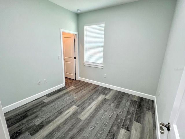 unfurnished room featuring baseboards and wood finished floors