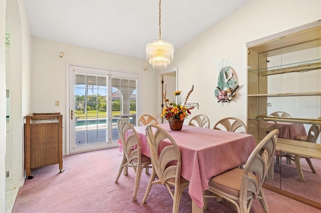 dining space with a notable chandelier and light colored carpet