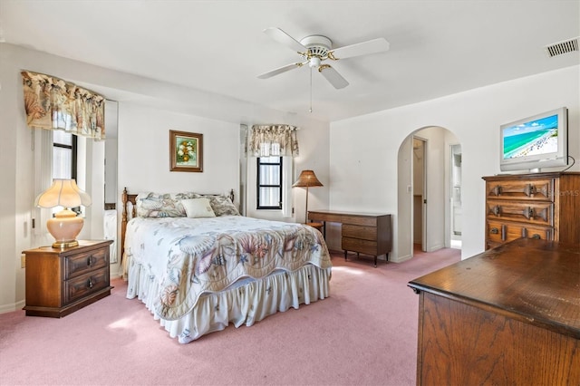 bedroom with a ceiling fan, arched walkways, visible vents, and carpet floors