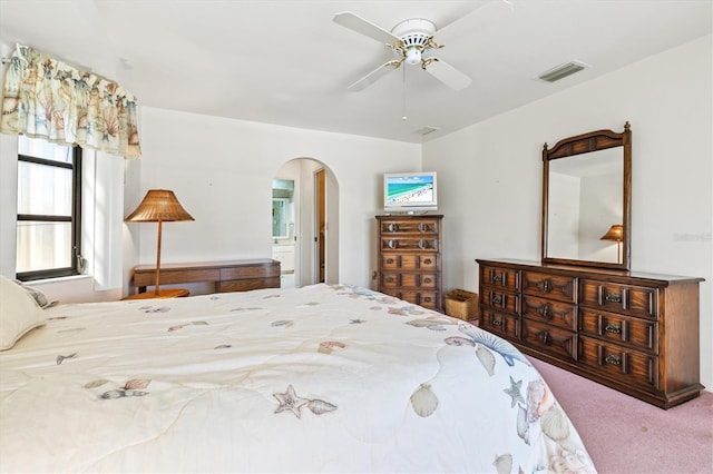 bedroom featuring visible vents, arched walkways, carpet floors, and ceiling fan