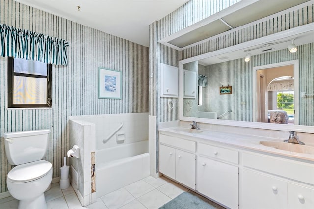 ensuite bathroom featuring wallpapered walls, tile patterned floors, and a sink