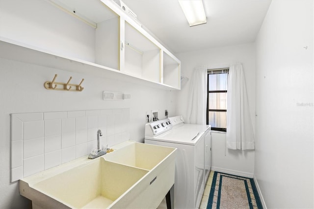 washroom featuring independent washer and dryer, a sink, light tile patterned floors, baseboards, and laundry area