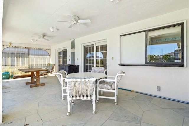 view of patio with outdoor dining area and a ceiling fan