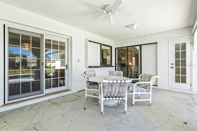 unfurnished sunroom with a ceiling fan