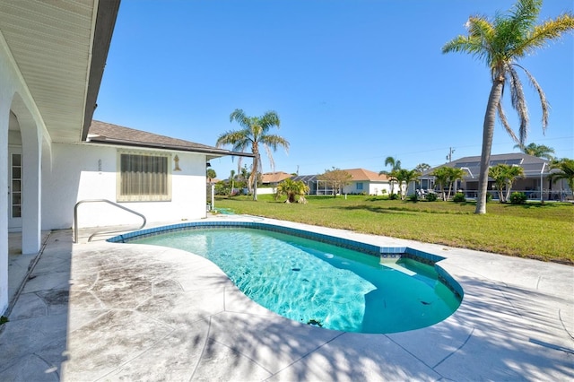 outdoor pool with a patio area, a residential view, and a yard