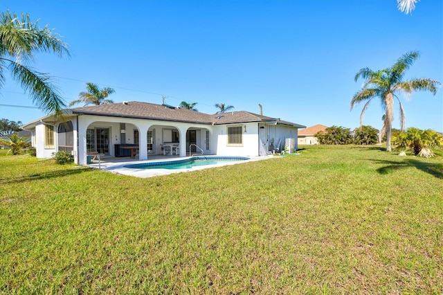 back of house featuring an outdoor pool, a yard, stucco siding, and a patio area