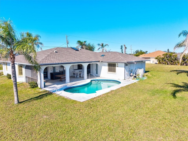 view of pool with a patio and a lawn