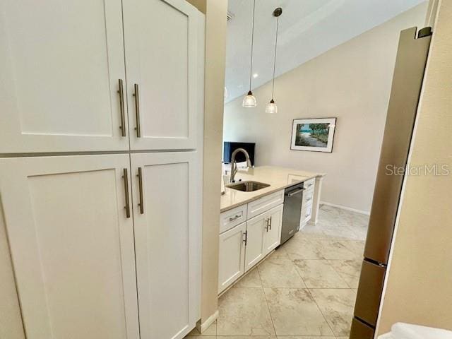 kitchen with white cabinets, stainless steel appliances, light countertops, pendant lighting, and a sink