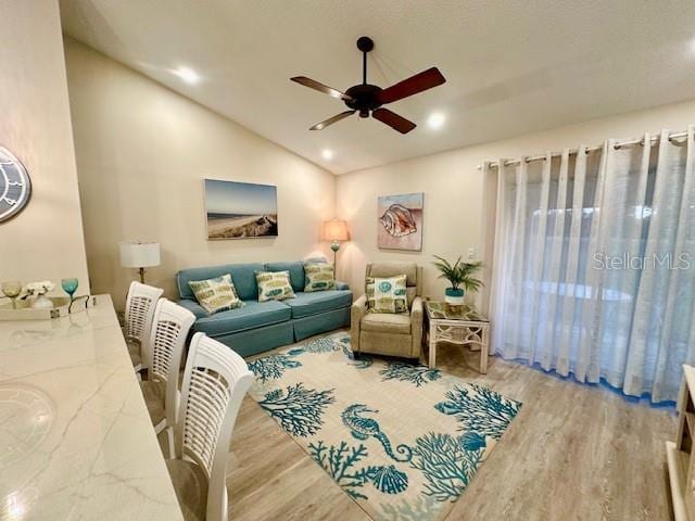 living area with lofted ceiling, ceiling fan, wood finished floors, and recessed lighting