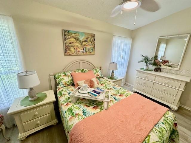 bedroom featuring ceiling fan, vaulted ceiling, and wood finished floors