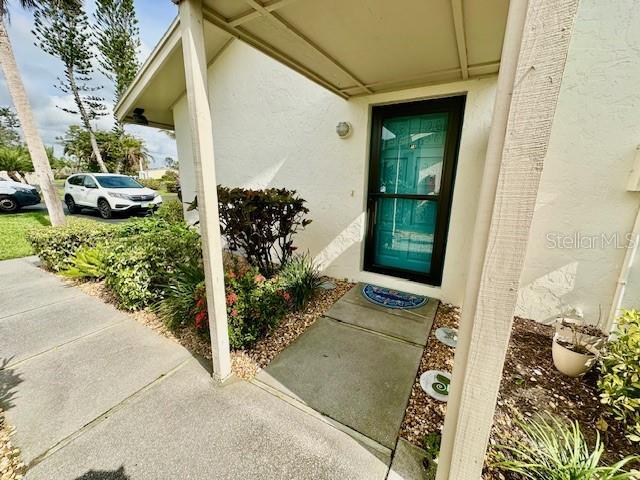 doorway to property featuring stucco siding