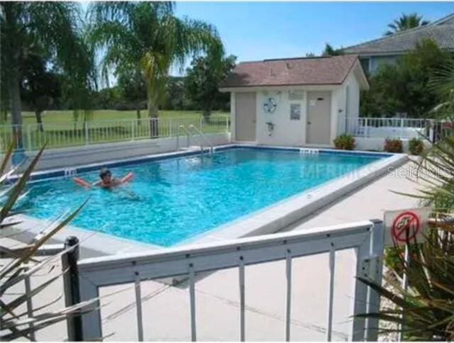 community pool featuring a patio area and fence