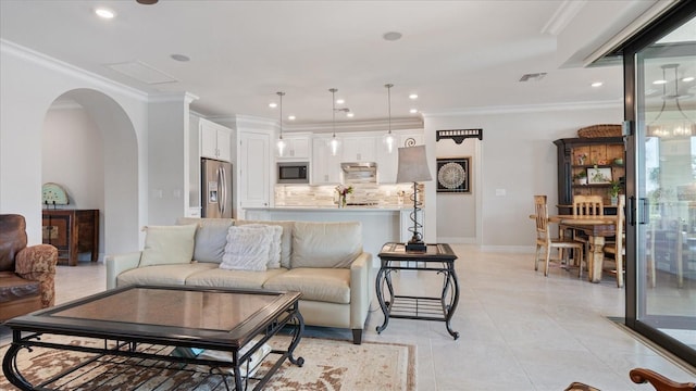 living area with arched walkways, light tile patterned floors, visible vents, and crown molding