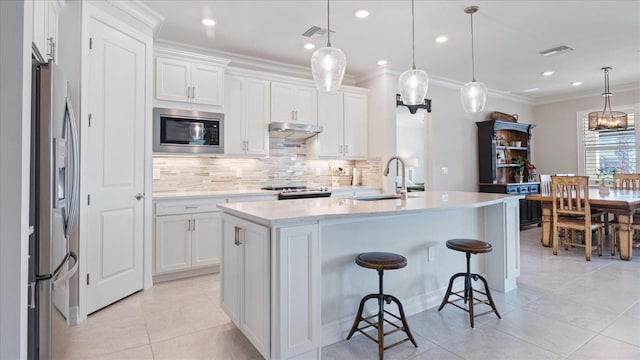 kitchen with crown molding, stainless steel refrigerator with ice dispenser, a sink, built in microwave, and under cabinet range hood