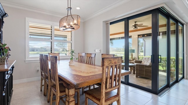 dining space with a notable chandelier, crown molding, baseboards, and light tile patterned floors