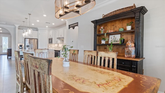 dining area with arched walkways, crown molding, and recessed lighting