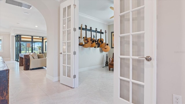 hall with light tile patterned floors, baseboards, arched walkways, ornamental molding, and french doors