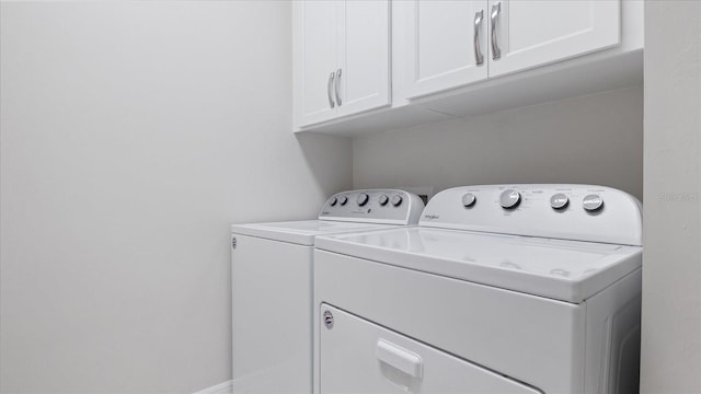 washroom with cabinet space and washer and dryer