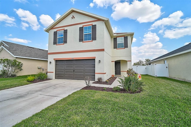 view of front facade with stucco siding, concrete driveway, a front yard, fence, and a garage