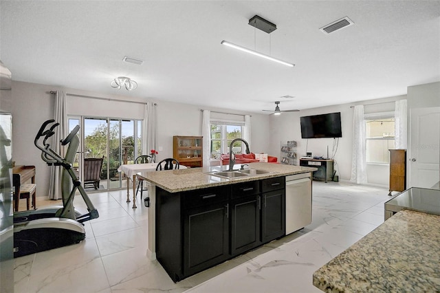 kitchen with marble finish floor, stainless steel dishwasher, a sink, and dark cabinets