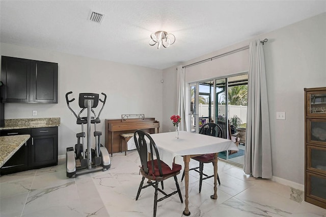 dining room featuring marble finish floor, baseboards, visible vents, and a textured ceiling